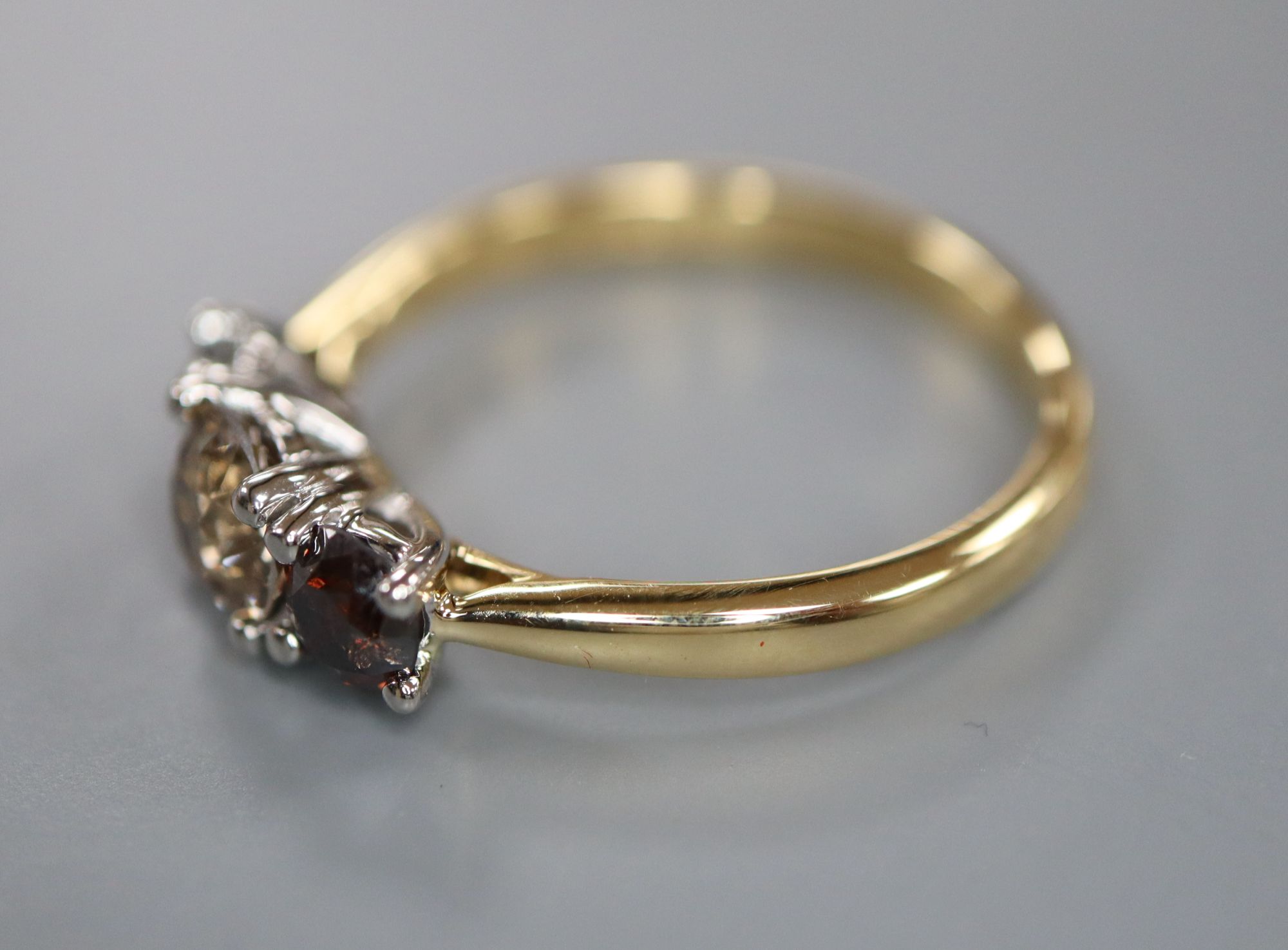 A modern 18ct gold and platinum, three stone two colour diamond set ring, size M, gross weight 3.5 grams.